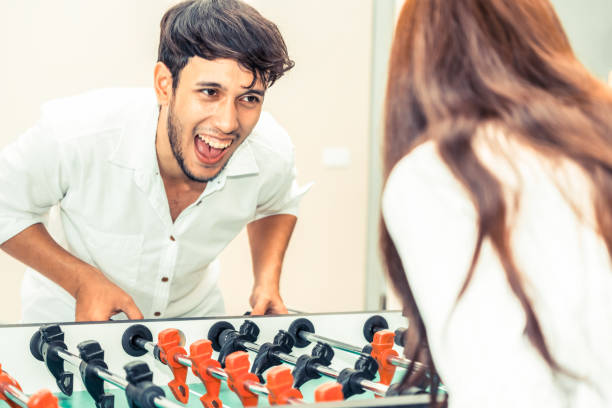 istock Happy couple playing foosball table. 1015934032