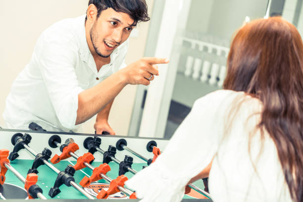 istock Happy couple playing foosball table. 1015934102