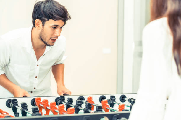 istock Happy couple playing foosball table. 1015934110