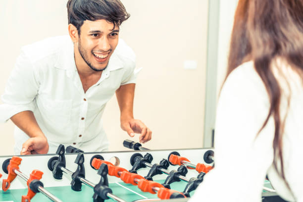 istock Happy couple playing foosball table. 1015934118