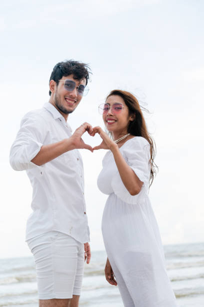 istock Young couple shows heart shape hand gesture. 1015934350