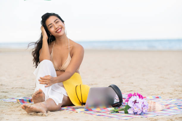 istock Plus size young woman sitting on the beach. 1015934770