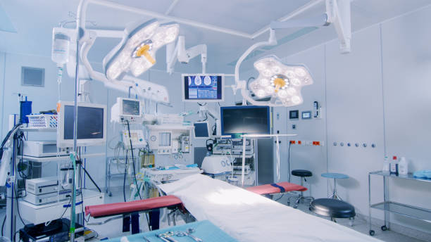 schuss von technologisch fortschrittlichen op-saal mit niemand, etabliert bereit für die chirurgie. real modern operating theater mit ausrüstung, beleuchtung und computer bereit für chirurgen und einem patienten. - operationssaal stock-fotos und bilder