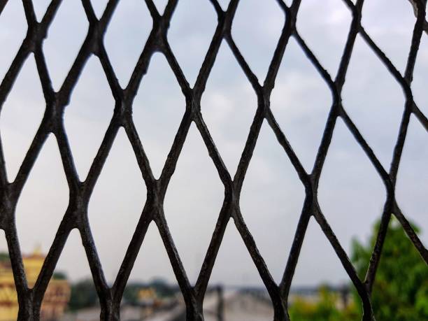 istock view of a blurred sky cityscape through diamond shaped grill 1015935216
