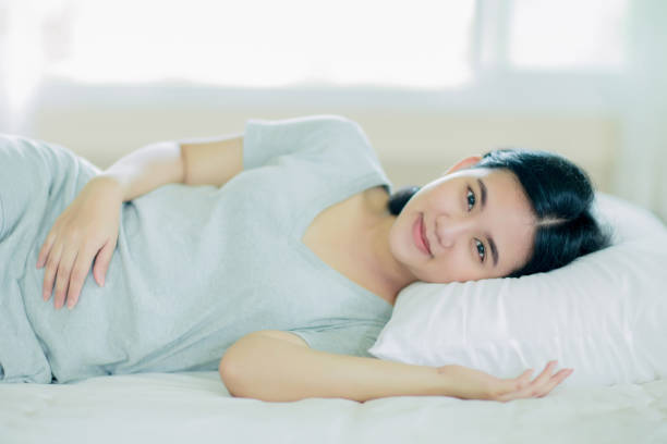 istock Asian girl  lay down on the bed 1015937654