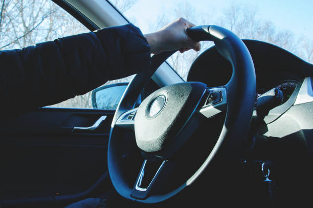 istock a young woman driving a car on a sunny day 1015939094