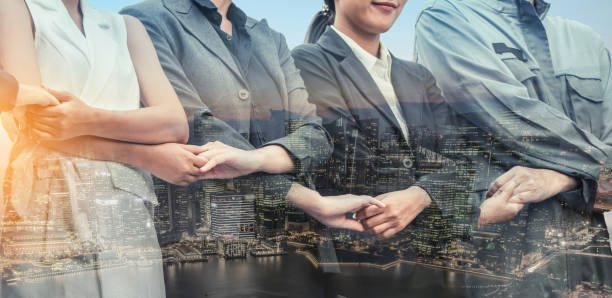 istock Double exposure business people holding hands. 1015941466