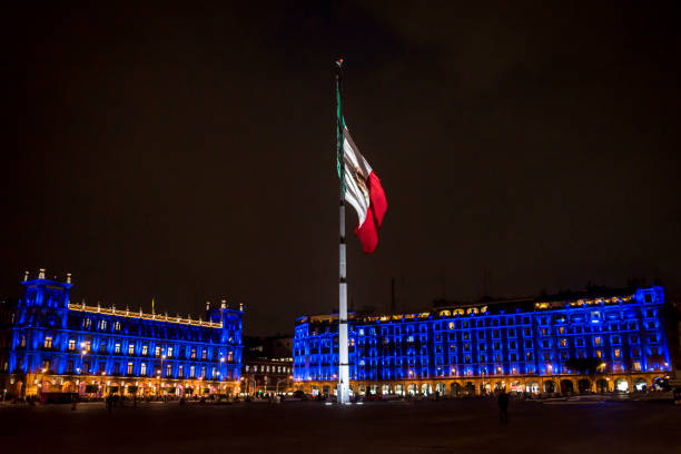 immense drapeau mexicain sur mât de drapeau à la place principale de la ville de mexico ou de zócalo, officiellement connue comme la place plaza de la constitución ou constitution pendant la nuit, mexico city, mexique - place mat photos et images de collection