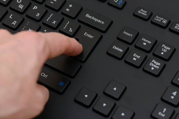 index finger presses the Enter key on the black keyboard index finger presses the Enter key on the black keyboard enter key stock pictures, royalty-free photos & images