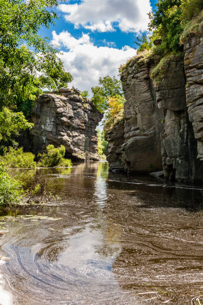 istock Canyon between which flows a river against the blue sky and green trees 1015950108