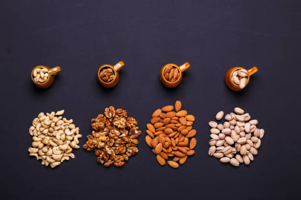 istock Assortment of nuts on a black background - healthy snack. 1015953174