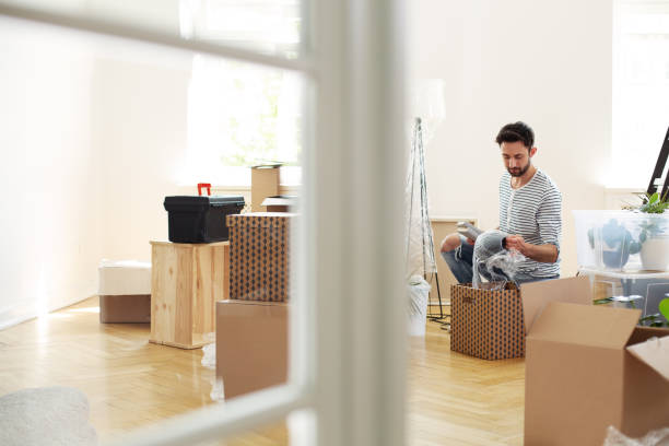 istock Man unpacking stuff from boxes while furnishing new flat after relocation 1015953236
