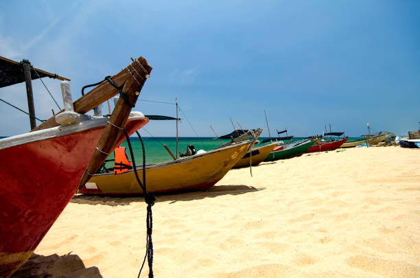 istock fisherman boat stranded on sandy beach bright sunny day and blue sky background 1015953424