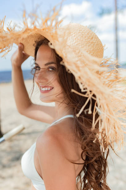 istock cheerful attractive girl posing in straw hat in summer 1015953686