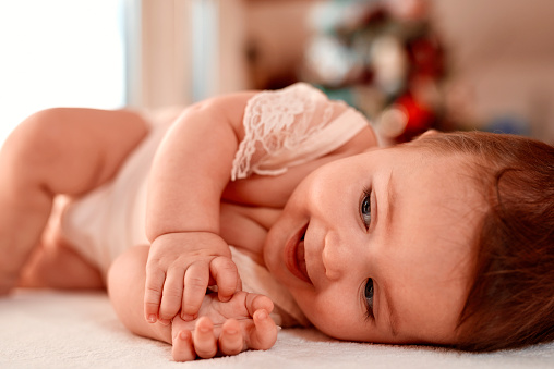 cute baby girl laughing and enjoying playing.lying on side.