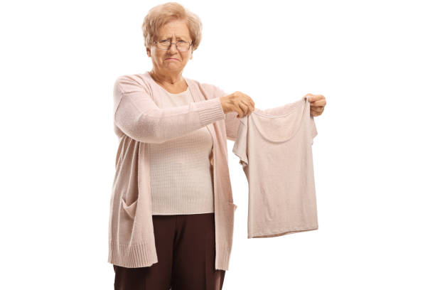 An elderly woman in a vest gestures with open arms, expressing her curiosity and openness to her surroundings
