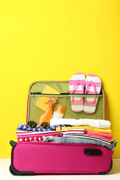istock Opened suitcase with clothes, sunglasses and sunscreen bottles 1015962484