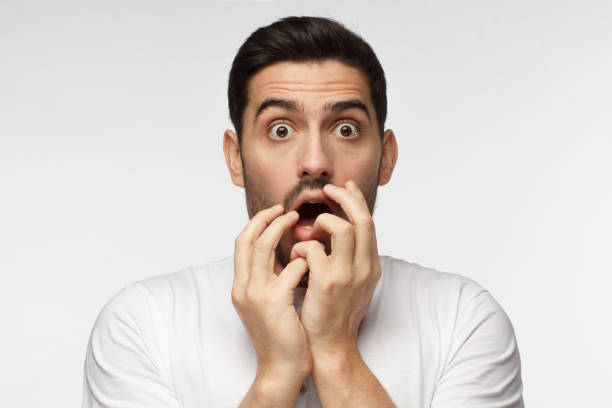 istock Astonished bug-eyed man covering his mouth with both hands, looking shocked. Surprised, embarrassed and confused young male showing omg emotion 1015970416