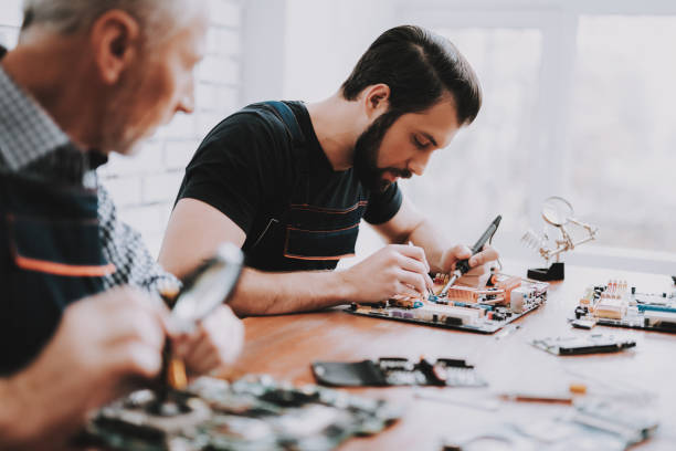 dwóch mężczyzn naprawy sprzętu sprzętowego z komputera. - male magnifying glass caucasian technician zdjęcia i obrazy z banku zdjęć