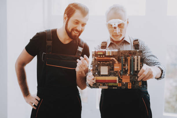 dwóch mężczyzn sprawdzanie sprzętu sprzętowego z komputera. - male magnifying glass caucasian technician zdjęcia i obrazy z banku zdjęć