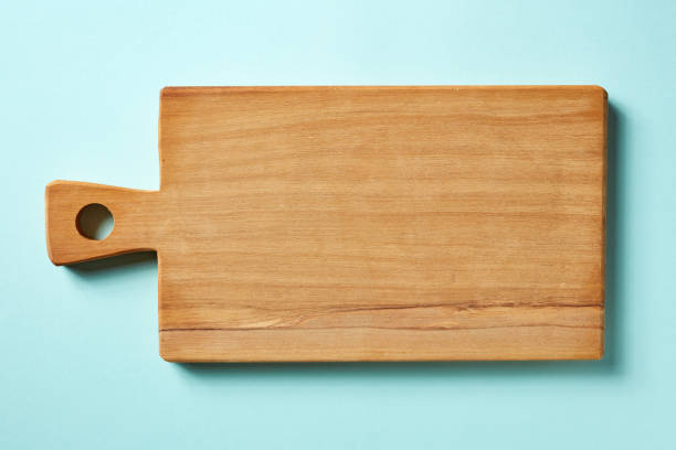 istock Wooden cutting board on blue background, from above 1015975760