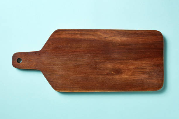 istock Wooden cutting board on blue background, from above 1015975818