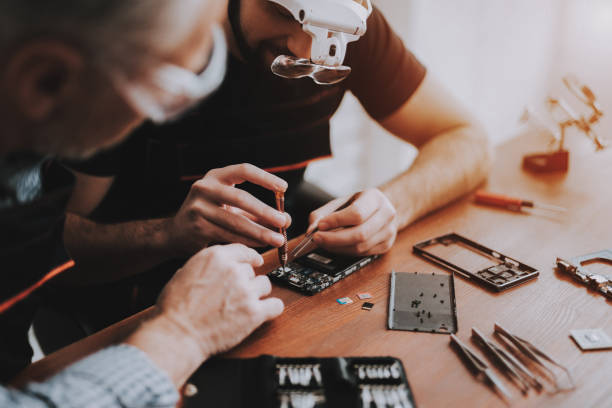 istock Two Men Repairing Hardware Equipment in Workshop. 1015976162