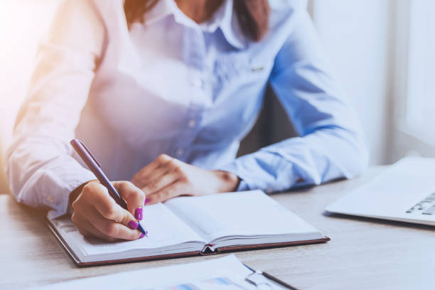 istock Businesswoman Writing in Notebook in Office . 1015989086