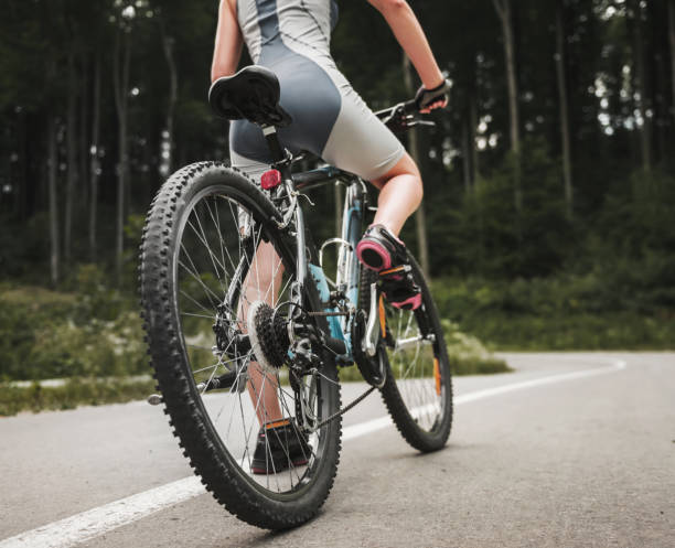 istock Young Woman Riding on Mountain Bicycle near Forest 1015989552