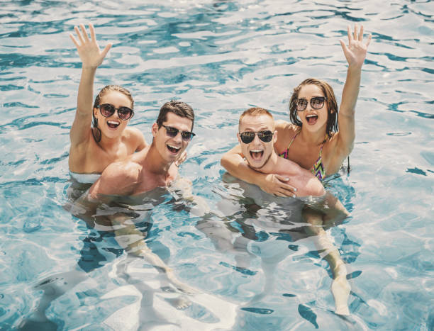 istock Beautiful Young People Having Fun in Swimming Pool 1015989672