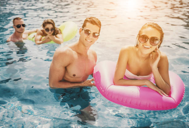 istock Beautiful Young People Having Fun in Swimming Pool 1015989724