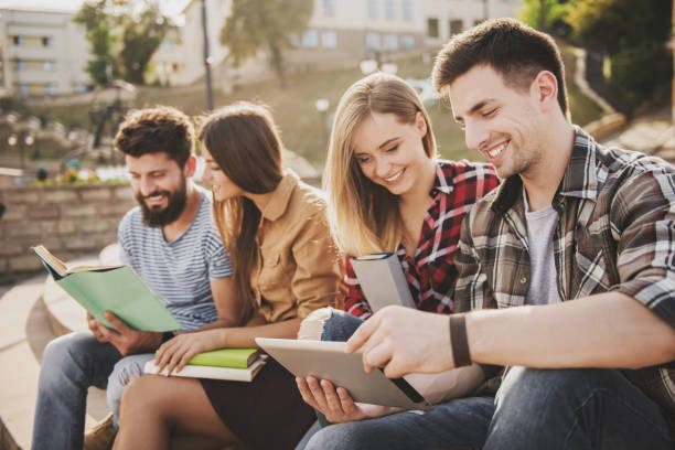 istock Young People Sitting in Park and Read Books. 1015994236