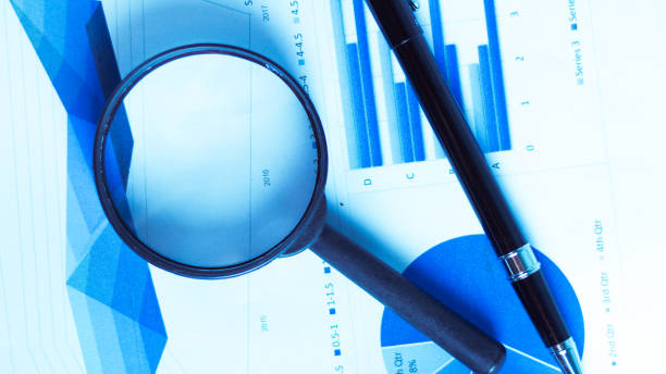 istock Business Analysis and Statistics Reports from sales charts last year using a magnifying glass. 1015994464