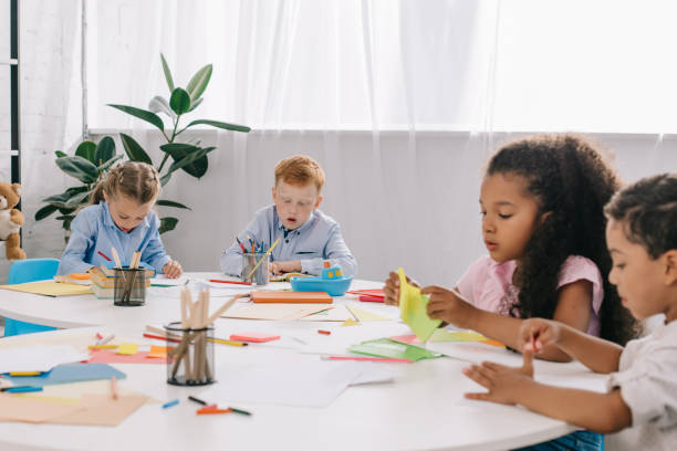 istock multicultural preschoolers drawing pictures with pencils in classroom 1015998352