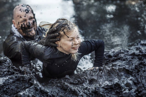 istock Father and daughter at mud run course 1015999096