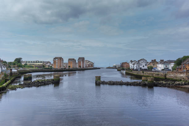 From the New Bridge at Ayr looking over the ruined foundations and pillars of the old bridge in the historic town of Ayr in Scotland.