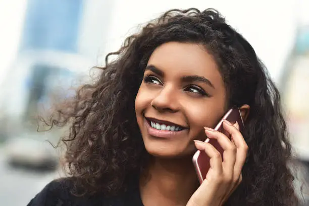 Photo of Positive emotions. Lifestyle concept. Close up of young mixed race woman use a phone.