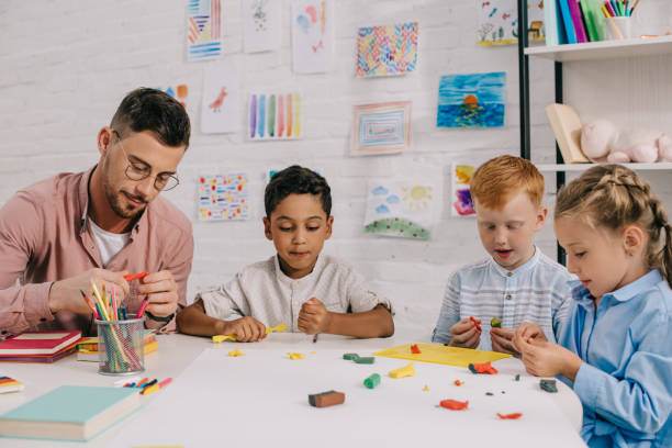 istock multiracial preschoolers and teacher with plasticine sculpturing figures at table in classroom 1016014566