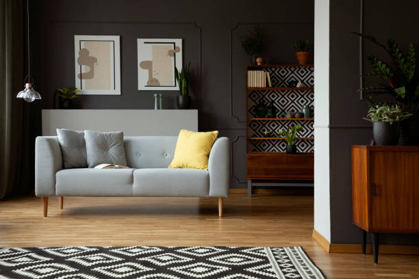 istock Patterned carpet in front of grey sofa in scandi living room interior with posters and lamp. Real photo 1016018592