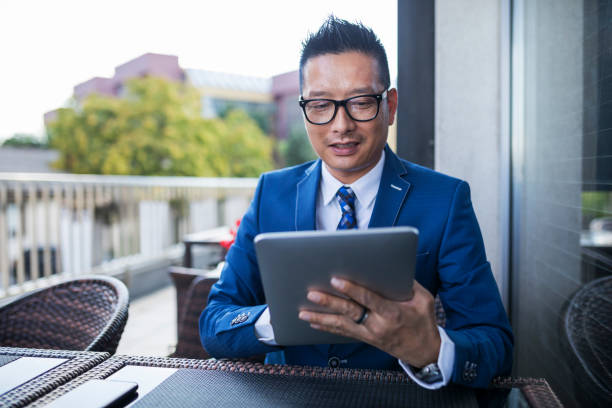istock Mature Asian businessman working on digital tablet 1016024006