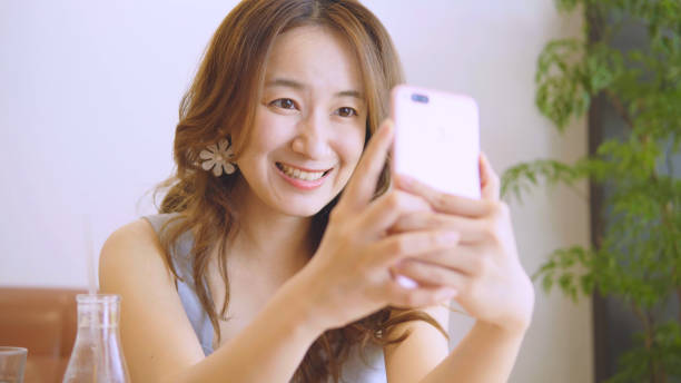 istock Asian woman using smart phone in restaurant 1016031576