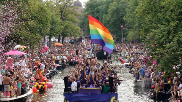 canal de amsterdam gay pride parade y escena de la gente en los países bajos - gay pride rainbow flag homosexual fotografías e imágenes de stock