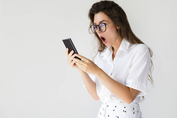 empresaria con expresión de la cara sorprendido es con smartphone - shock surprise people business fotografías e imágenes de stock