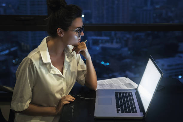 istock Woman is working with laptop at home during night. 1016042626