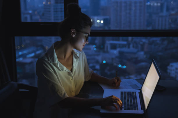 istock Woman is working with laptop at home during night. 1016042644