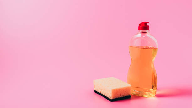 close up view of dishwashing liquid and washing sponge, pink background - dishwashing detergent imagens e fotografias de stock