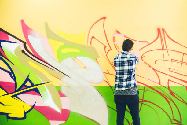 istock Man painting graffiti on orange wall 1016073818