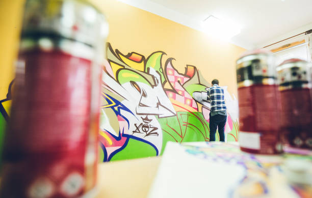 istock Man painting graffiti on orange wall 1016073890