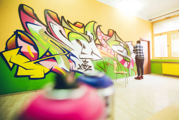 istock Man painting graffiti on orange wall 1016073958