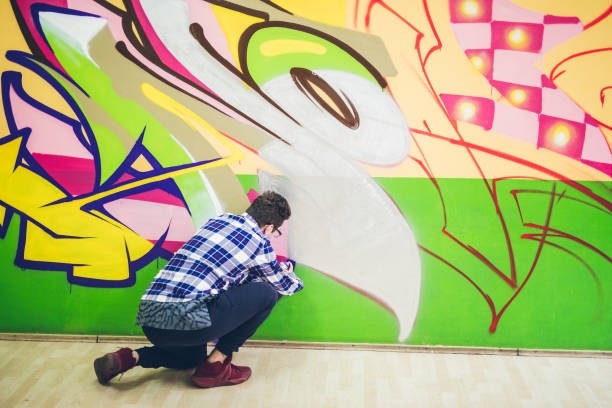 istock Man painting graffiti on orange wall 1016074038